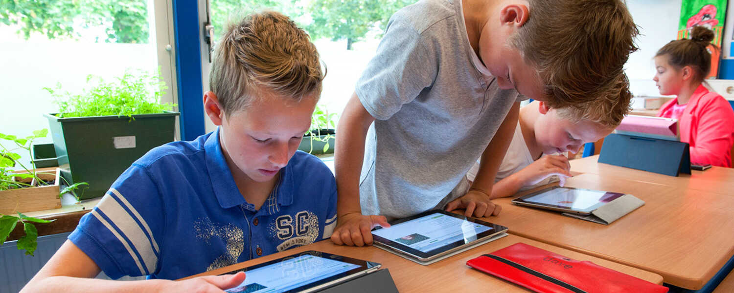 Leerlingen werken samen met tablets in de klas